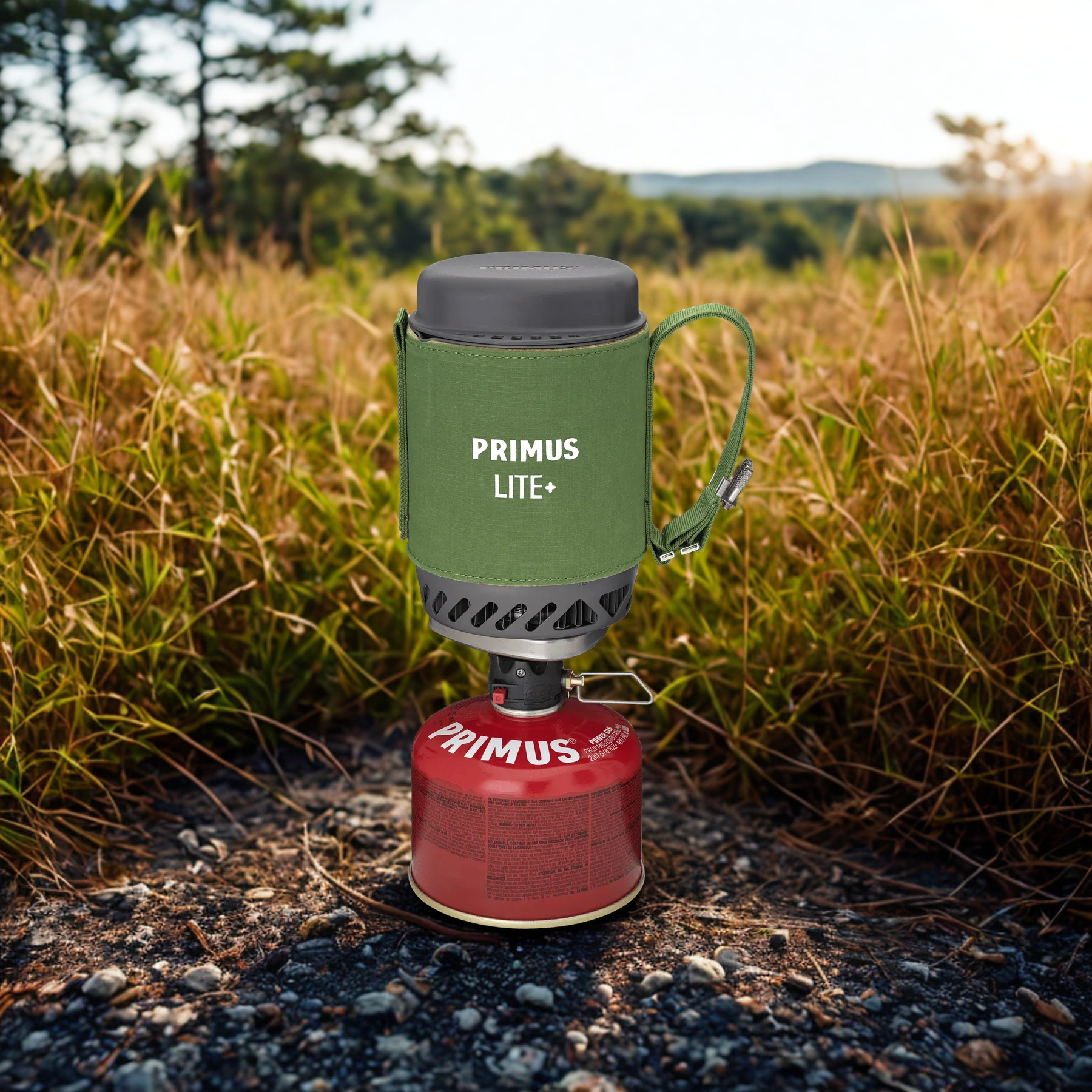 Primus Lite+ camping stove with green container in a natural setting