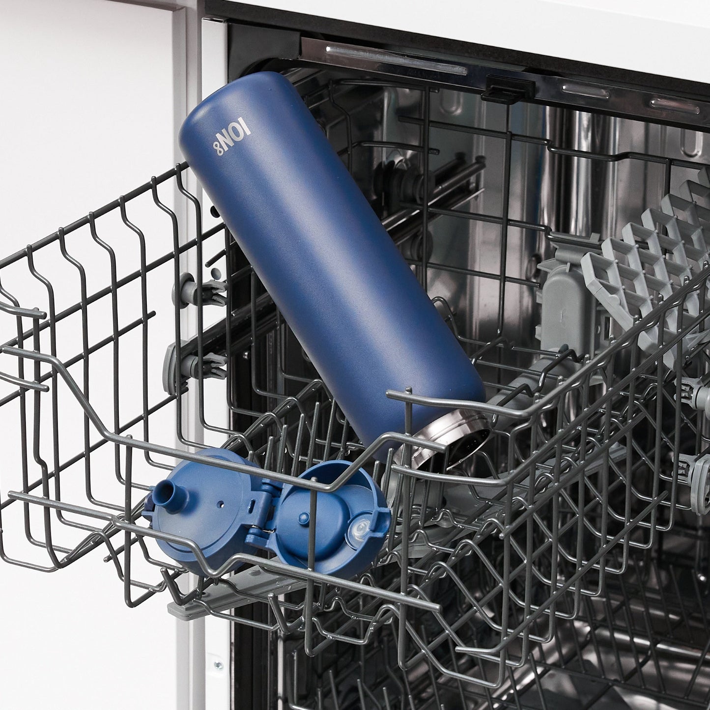 Blue bottle inside a dishwasher with a focus on cleaning.