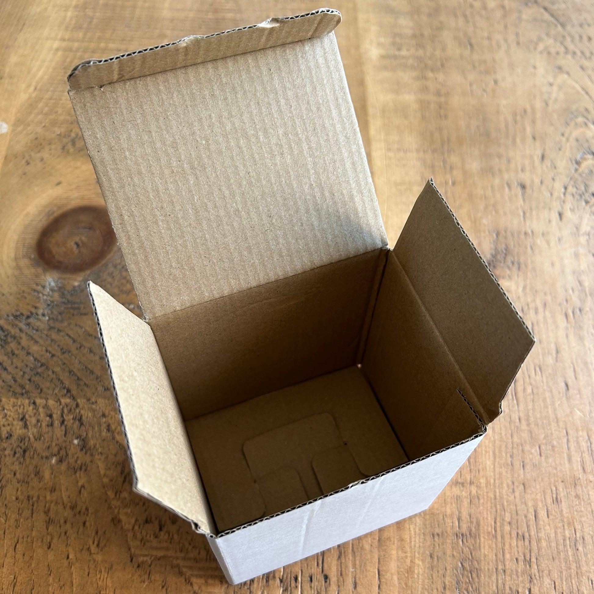 Open cardboard box on a wooden surface