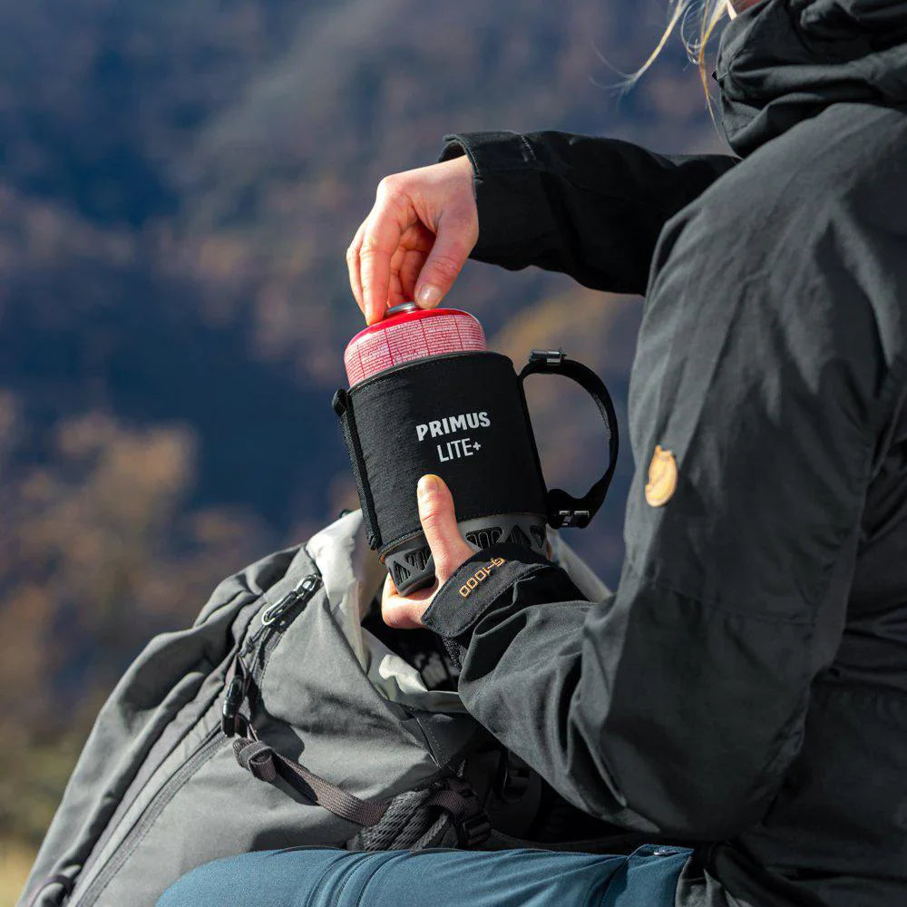 Person holding a Primus Lite+ mug with a scenic mountain background