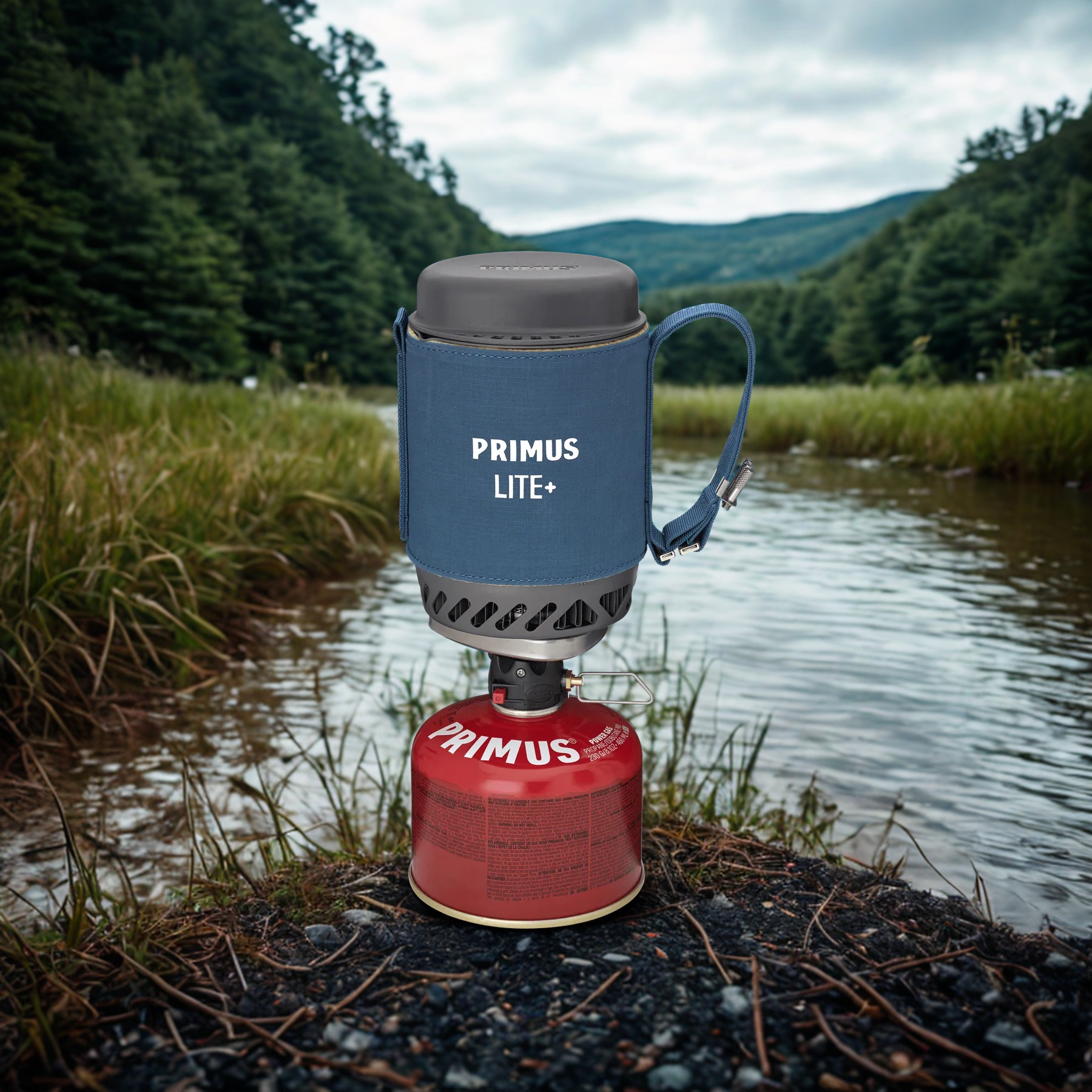 Primus Lite camping stove with blue container and red canister on a natural background
