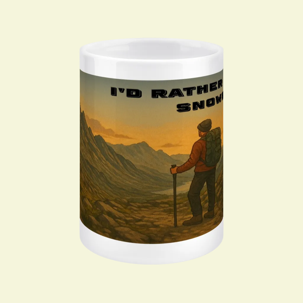 White ceramic mug with hiking scene and text "I’d Rather Be in Snowdonia" in bold black letters.