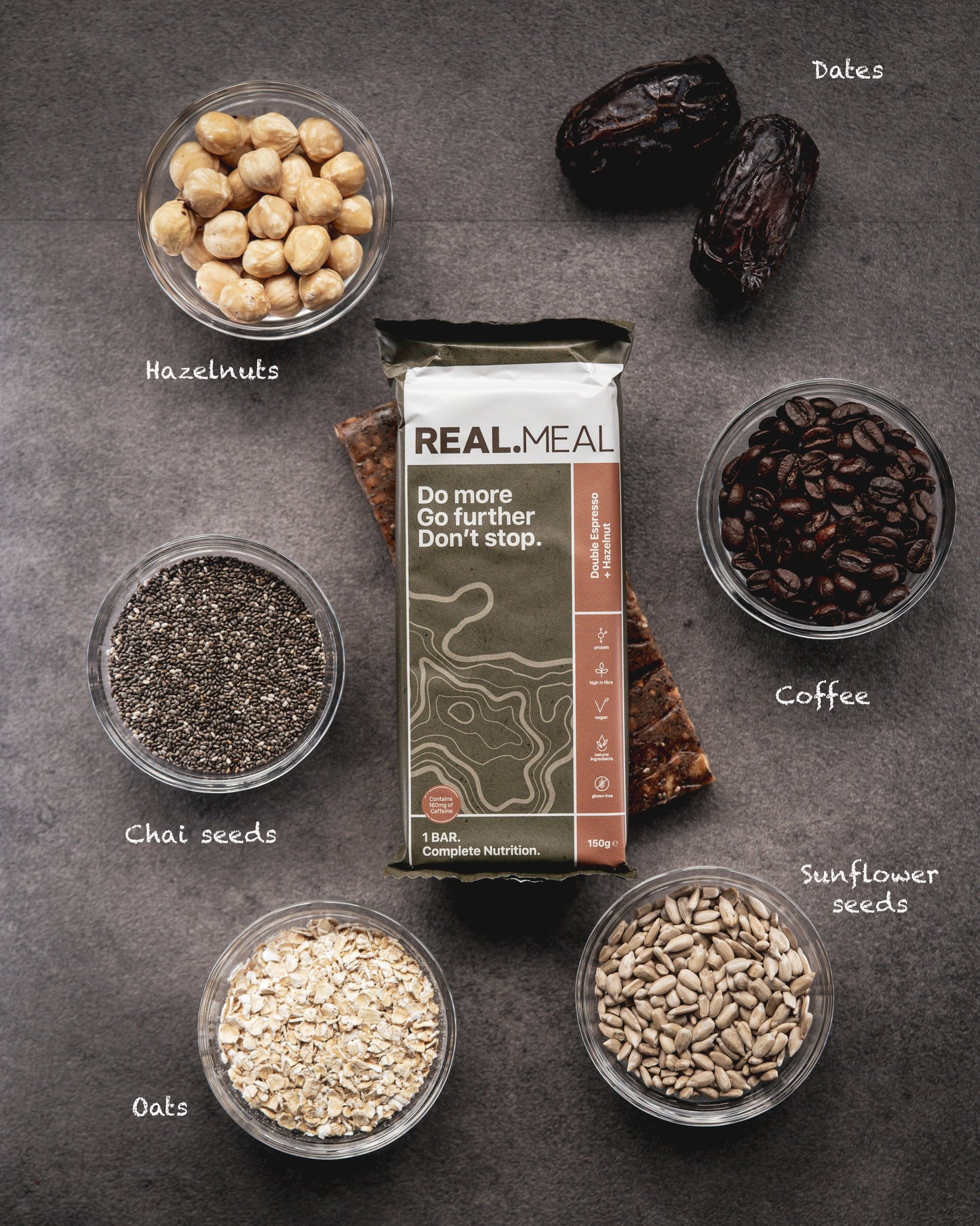 REAL MEAL package surrounded by ingredients on a dark surface