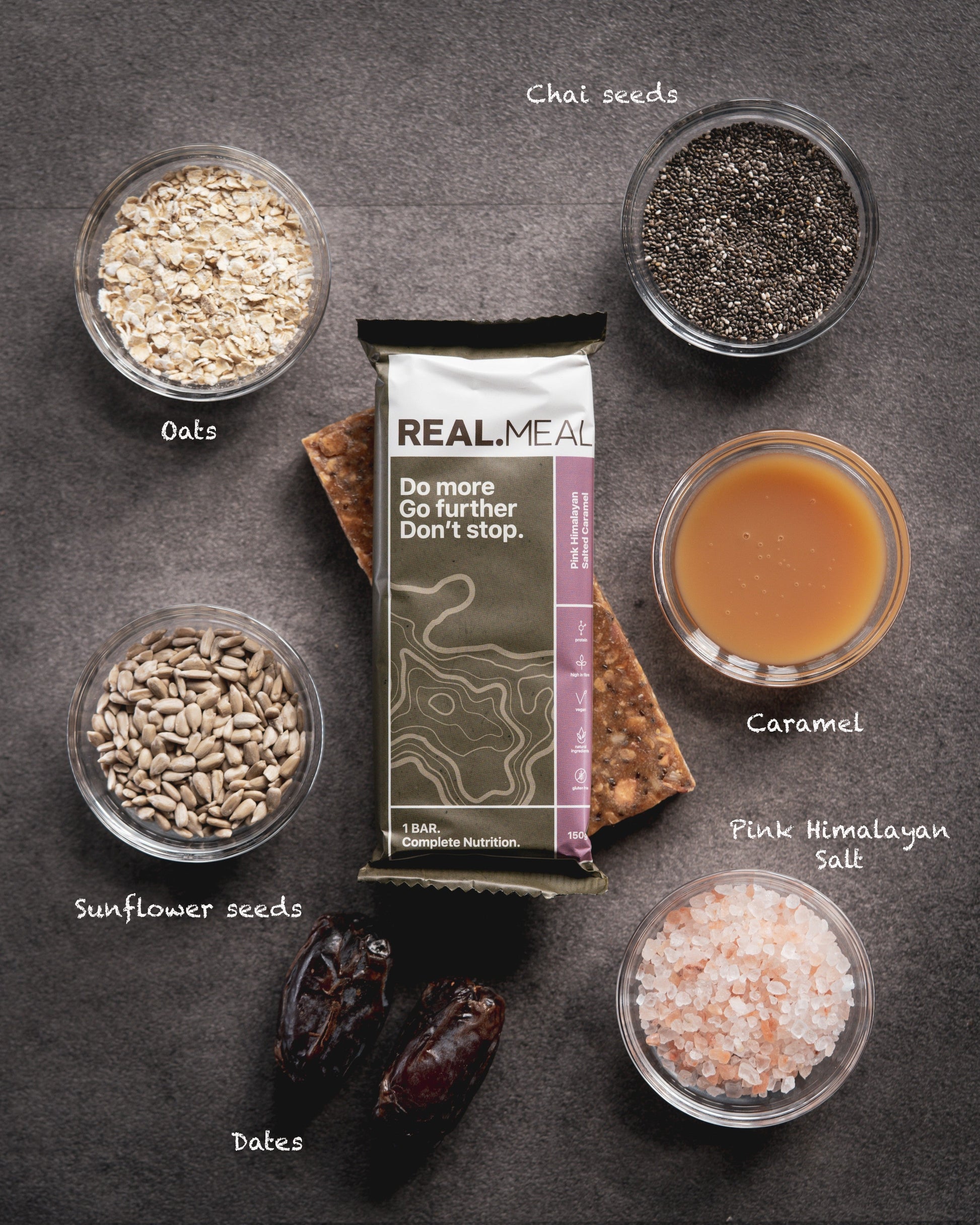 REAL MEAL package surrounded by ingredients on a dark surface