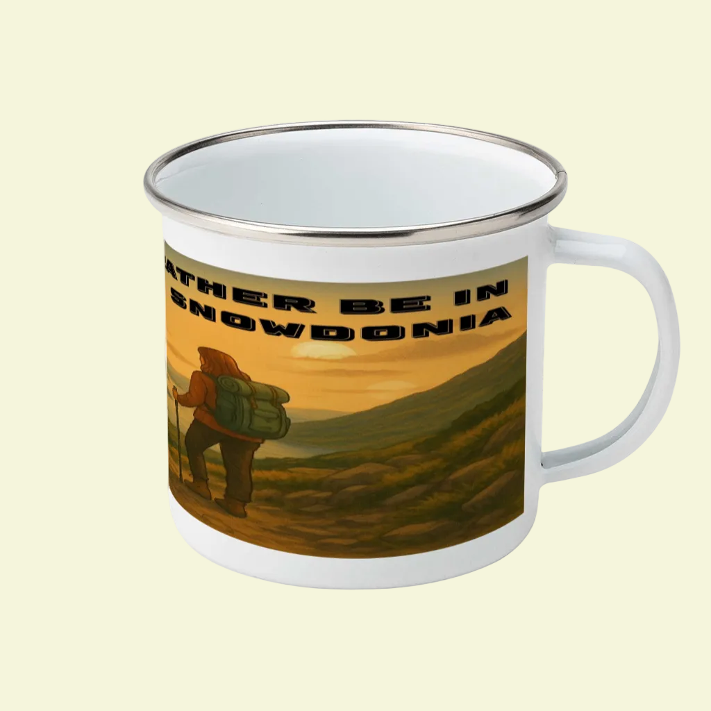 White enamel mug with black rim, featuring hiker illustration and "I'd Rather Be in Snowdonia" text.