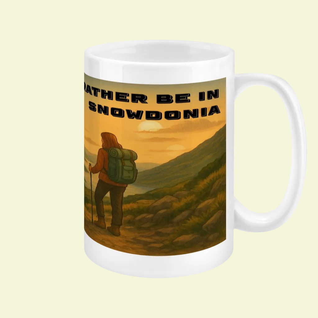 White ceramic mug with large handle featuring a hiker overlooking a mountainous landscape at sunset and black text "Rather.